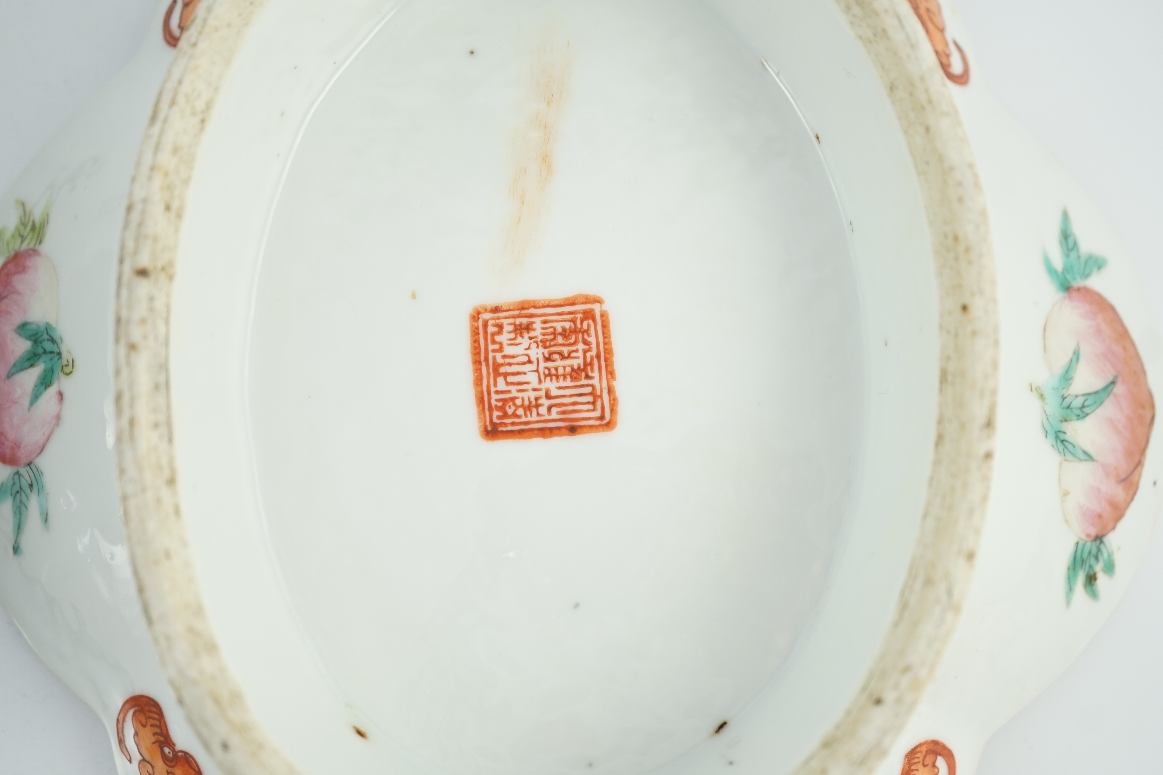 A Chinese famille rose 'butterfly and flowers' dish, Daoguang period and an iron red enamelled 'sanduo' dish, late 19th century